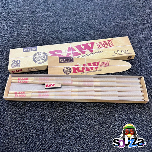 Open box of Raw rolling papers with cigarettes on a dark textured surface, featuring the Raw logo.
