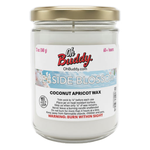 Jar of Oh Buddy candle labeled 'Seaside Blossom' with a gold lid on a white background